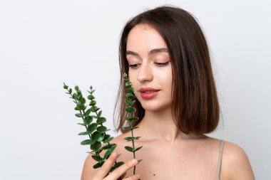 Beyaz arka planda izole edilmiş genç Ukraynalı kadın bir okaliptüs dalı tutuyor. Portreyi kapat