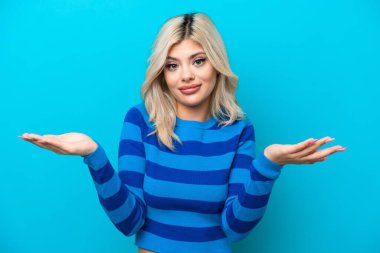 Mavi arka planda izole edilmiş genç bir Rus kadının şüpheleri var.