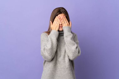 Mor arka planda izole edilmiş genç Slovak kadın gözlerini elleriyle kapatıyor.