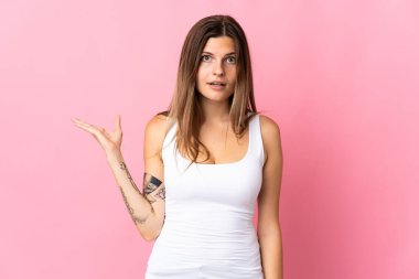 Pembe arka planda izole edilmiş genç Slovak kadın şüpheli hareketler yapıyor.