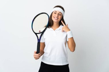 İzole edilmiş beyaz arka planda genç bayan tenisçi baş parmak hareketi yapıyor.