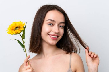 Genç Ukraynalı kadın gülümserken elinde ayçiçeği tutarak beyaz arka planda izole edilmiş. Portreyi kapat