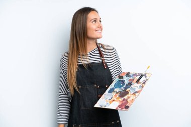 Beyaz arka planda izole edilmiş bir palet tutan beyaz kadın.