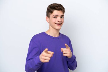 Beyaz arka planda izole edilmiş genç bir Rus ön tarafı işaret ediyor ve gülümsüyor.