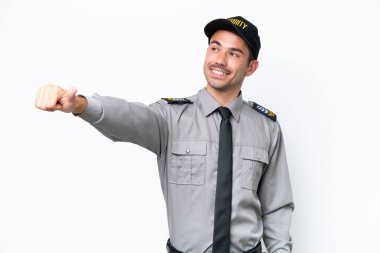 İzole edilmiş beyaz arka planda genç bir güvenlik görevlisi baş parmak hareketi yapıyor.