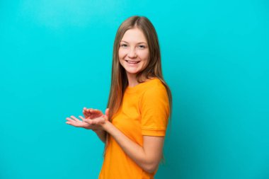 Mavi arka planda izole edilmiş genç Rus kadın alkışlıyor.