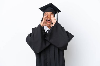 Genç üniversite mezunu Afro-Amerikalı bir kadın beyaz arka planda izole edilmiş bağırıyor ve bir şeyler duyuruyor.