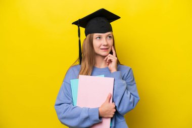 Genç Rus öğrenci, sarı arka planda izole edilmiş bir şekilde bir fikir ararken...