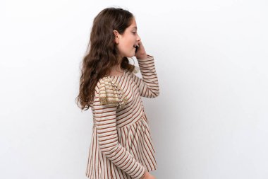 Beyaz arka planda izole edilmiş küçük bir kız cep telefonuyla sohbet ediyor.