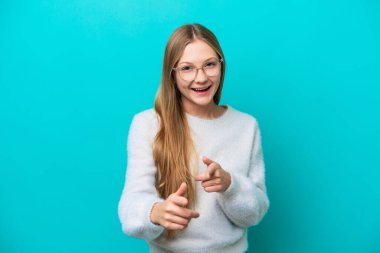 Mavi arka planda izole edilmiş genç bir Rus kadın ön tarafı gösteriyor ve gülümsüyor.
