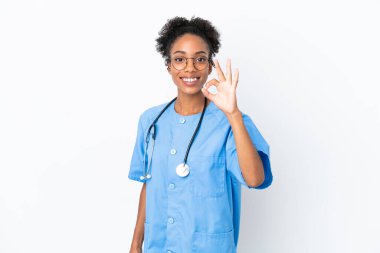 Genç cerrah Afrikalı Amerikalı kadın izole edilmiş beyaz arka planda parmaklarıyla tamam işareti gösteriyor.