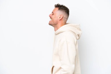 Beyaz arka planda izole edilmiş beyaz tenli yakışıklı adam yan yana gülüyor.