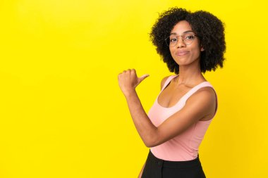 Sarı arka planda kendini beğenmiş ve gururlu genç Afrikalı Amerikalı kadın.