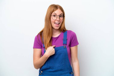 Genç kızıl saçlı kadın, beyaz arka planda izole edilmiş ve yüzünde sürpriz bir ifade var.