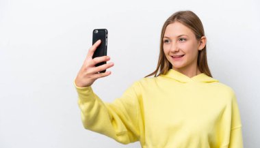 Beyaz arka planda izole edilmiş genç bir Rus kadın selfie çekiyor.