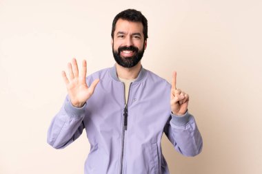 Sakallı, ceketli, soyutlanmış arka planda beyaz bir adam. Parmakları olan altı kişi saydım.