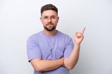 Beyaz arka planda izole genç beyaz adam mutlu ve yukarı işaret