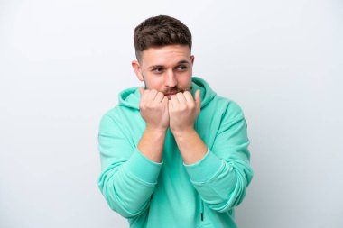 Beyaz arka planda izole edilmiş genç beyaz bir adam gergin ve korkmuş bir şekilde elleriyle suni teneffüs yapıyor.