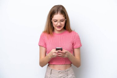 Beyaz arka planda izole edilmiş genç bir Rus kız cep telefonuyla mesaj gönderiyor.