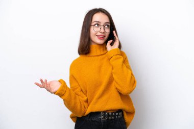 Beyaz arka planda izole edilmiş genç Ukraynalı bir kadın cep telefonuyla sohbet ediyor.