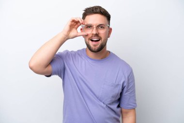 Beyaz arka planda izole edilmiş genç beyaz adam parmaklarıyla tamam işareti gösteriyor.