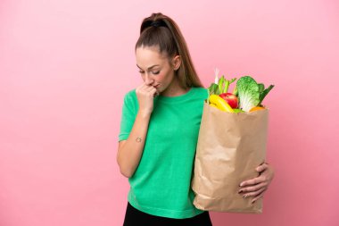 Elinde alışveriş poşeti tutan genç bir kadın şüpheleri var.