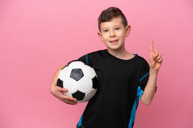 Little caucasian football player boy isolated on pink background showing and lifting a finger in sign of the best