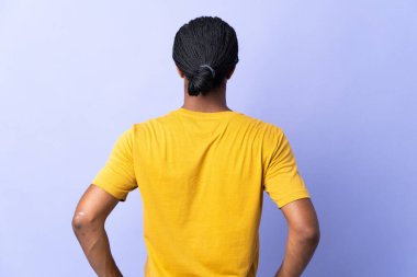 Örgülü genç Afrikalı Amerikalı adam arka planda mor arka planda izole edilmiş.