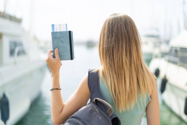 Arka tarafta pasaportu olan sarışın genç bir kadın var.