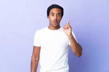 Örgülü genç Afrikalı Amerikalı adam mor arka planda izole edilmiş. Çözümü bulmak için parmağını kaldırıyor.