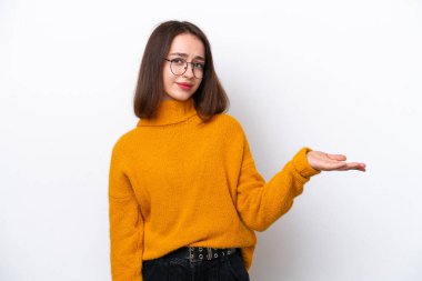 Genç Ukraynalı bir kadın beyaz arka planda izole edilmiş bir fikir sunuyor ve gülümsüyor.