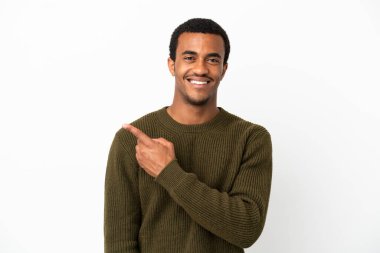 İzole edilmiş beyaz arka planda Afro-Amerikalı yakışıklı bir adam bir ürün sunmak için kenarı işaret ediyor