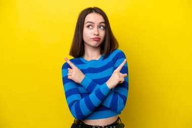 Sarı arka planda izole edilmiş genç Ukraynalı kadın, yandakilerin şüphelerine işaret ediyor.