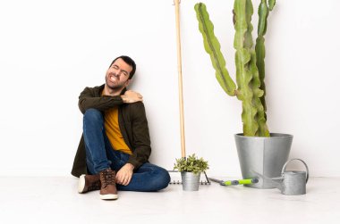 Bahçıvan içeride yerde oturuyor. Çabaladığı için omuz ağrısı çekiyor.