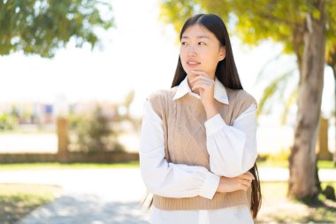Dışarıdaki güzel Çinli kadın yan tarafa bakıyor.