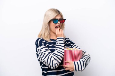 Beyaz arka planda 3 boyutlu gözlüklü ve elinde koca bir kova patlamış mısır tutan genç bir Rus kadın.