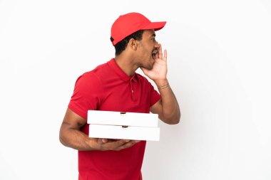 Afro-Amerikalı pizza teslimatçısı izole edilmiş beyaz duvarın üzerinden pizza kutuları alıyor ve ağızları sonuna kadar açık bağırıyor.