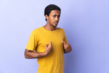Örgülü genç Afrikalı Amerikalı adam mor arka planda izole edilmiş. Kendini işaret ediyor.