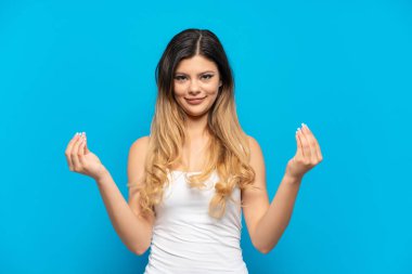Young Russian girl isolated on blue background making money gesture