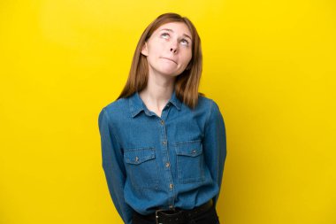 Sarı arka planda izole edilmiş genç bir İngiliz kadın var.