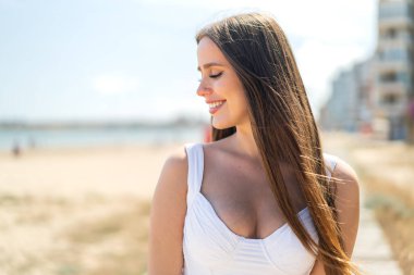 Açık havada genç bir kadın Neşeli bir ifadeyle