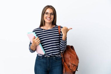 Beyaz arka planda izole edilmiş genç bayan bir ürünü sunmak için kenarı işaret ediyor.