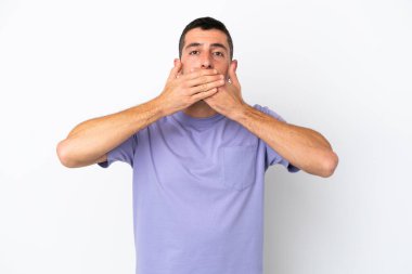 Beyaz arka planda izole edilmiş yakışıklı beyaz adam elleriyle ağzını kapatıyor.