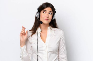 Beyaz arka planda kulaklıkla çalışan beyaz pazarlamacı kadın şans diliyor ve en iyisini diliyor.