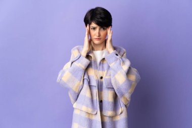 Kısa saçlı bir kadın, mor arka planda baş ağrısı ile izole edilmiş.