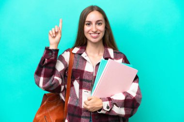 Young student caucasian woman isolated on blue background pointing up a great idea