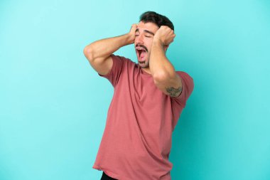 Mavi arka planda izole edilmiş genç beyaz adam bunalıma girdi.