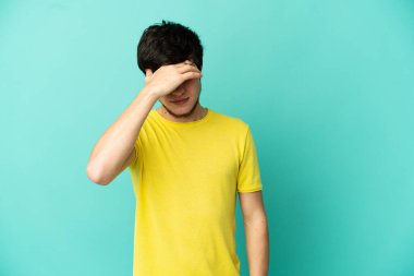Genç Rus adam mavi arka planda baş ağrısı ile izole edildi.