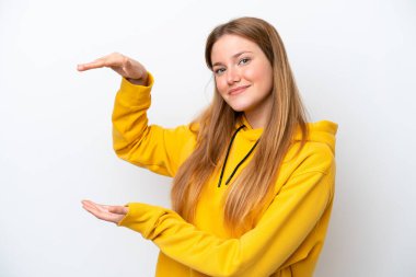 Beyaz arka planda izole edilmiş genç beyaz bir kadın ilan vermek için kopyalama alanı tutuyor.