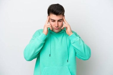 Beyaz arka planda başı ağrıyan genç beyaz bir adam.